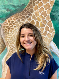Picture of staff member in front of giraffe wall mural