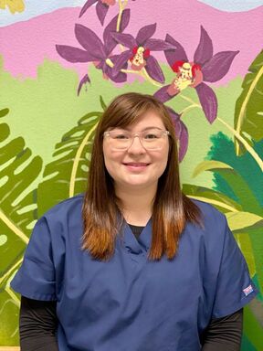 Picture of staff member in front of jungle wall mural